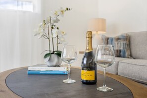 A bottle of Valdo Prosecco on a table with two wine glasses.