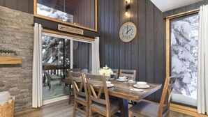A dining area with a wooden table, chairs, and a clock on the wall. - Walkable to Canyon Lodge w/ Ski Locker (Mammoth Lakes)