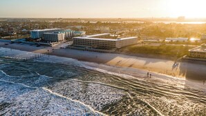 An aerial view of a beach with buildings, including a large hotel with multiple floors and a flat roof. - Amazing Ocean Front Property on Daytona Beach with amazing views & full kitchen (Daytona Beach)