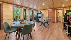 A wooden-floored room with a foosball table, a pool table, and a bar area. - Brand New Greenleaf Lodge ~Indoor Pool ~ Hot Tub (Sevierville)