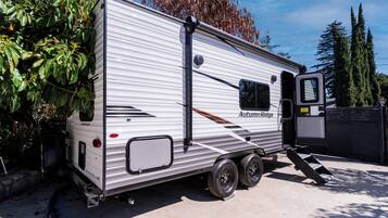 Una autocaravana con rampa, puerta lateral y ventana.
