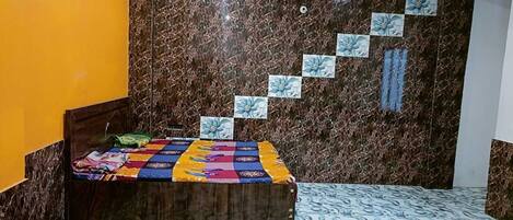 A bedroom with a bed, a ceiling fan, and a marble-patterned wall.