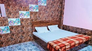 Ένα υπνοδωμάτιο με ένα κρεβάτι, ένα ξύλινο προσκέφαλο και έναν τοίχο με σχέδιο που μιμείται το μάρμαρο.