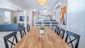 A modern dining area with a wooden table, black chairs, and a hanging light fixture. - Cozy Retreat in San Juan

 (san juan)