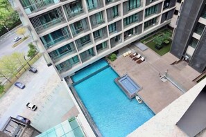 A modern building with a swimming pool, outdoor seating, and a well-maintained garden. - Homesuite' Home at Riverson Soho (Kota Kinabalu)