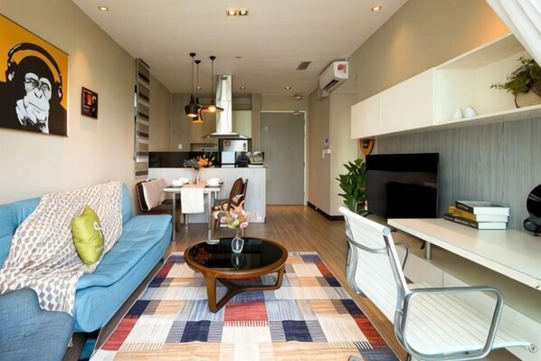 A modern living room with a sofa, coffee table, and a TV. - Homesuite' Home at Riverson Soho (Kota Kinabalu)