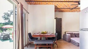 A dining area with a table set for four, a bench, and a sofa. - Lovely bungalow with WiFi in Chapala Haciendas (Chapala Haciendas)