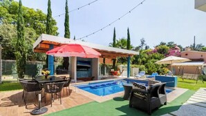 A backyard with a swimming pool, outdoor seating, and a barbecue area. - Lovely bungalow with WiFi in Chapala Haciendas (Chapala Haciendas)