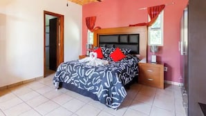 A bedroom with a bed, nightstands, a wooden cabinet, and a brick-patterned ceiling. - Lovely bungalow with WiFi in Chapala Haciendas (Chapala Haciendas)