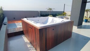 Una vasca idromassaggio su un terrazzo panoramico con vista sul mare.
