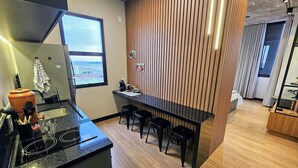 Una cucina moderna con un piano di lavoro nero, un piano cottura integrato e una finestra che si affaccia su un parcheggio.