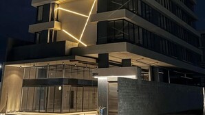 Un edificio a più piani dal design moderno, con un'imponente installazione luminosa geometrica sulla facciata.