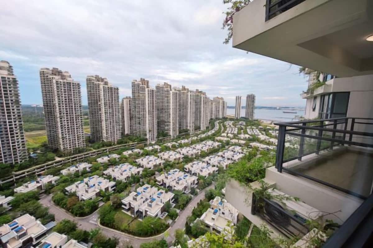 Un quartier résidentiel avec de grands immeubles, une rivière et un balcon offrant une vue panoramique.