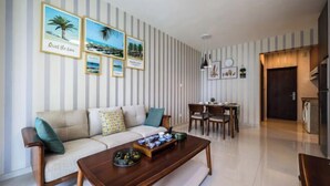 A modern living room with a sofa, coffee table, and framed pictures on the wall.