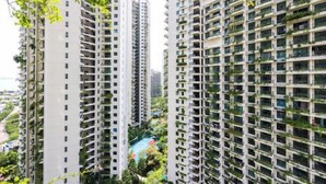 A high-rise residential building with multiple balconies, a rooftop pool, and surrounding greenery.