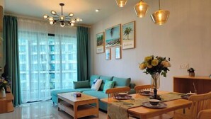 A modern living room with a sofa, dining table, chairs, and artwork on the wall.