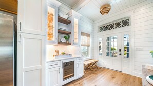 A kitchen with white cabinetry, a built-in oven, and a wooden dining table. - Rooftop Deck & Ocean Views—Luxury 5BR/4.5BA  Single Family, Across from Beach! (Ocean City)