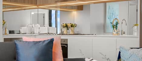 A modern kitchen with wooden cabinets, a countertop with a toaster, and a sink with a faucet.