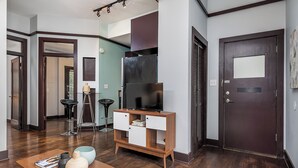 Una sala de estar moderna con un mueble de madera, un televisor y una mesa de centro con adornos.