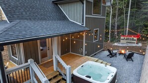 A house with a covered porch, a hot tub, and outdoor seating.