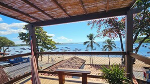 A wooden deck with a hammock, a bench, and a potted plant. - Casa Aberta (Itacaré)