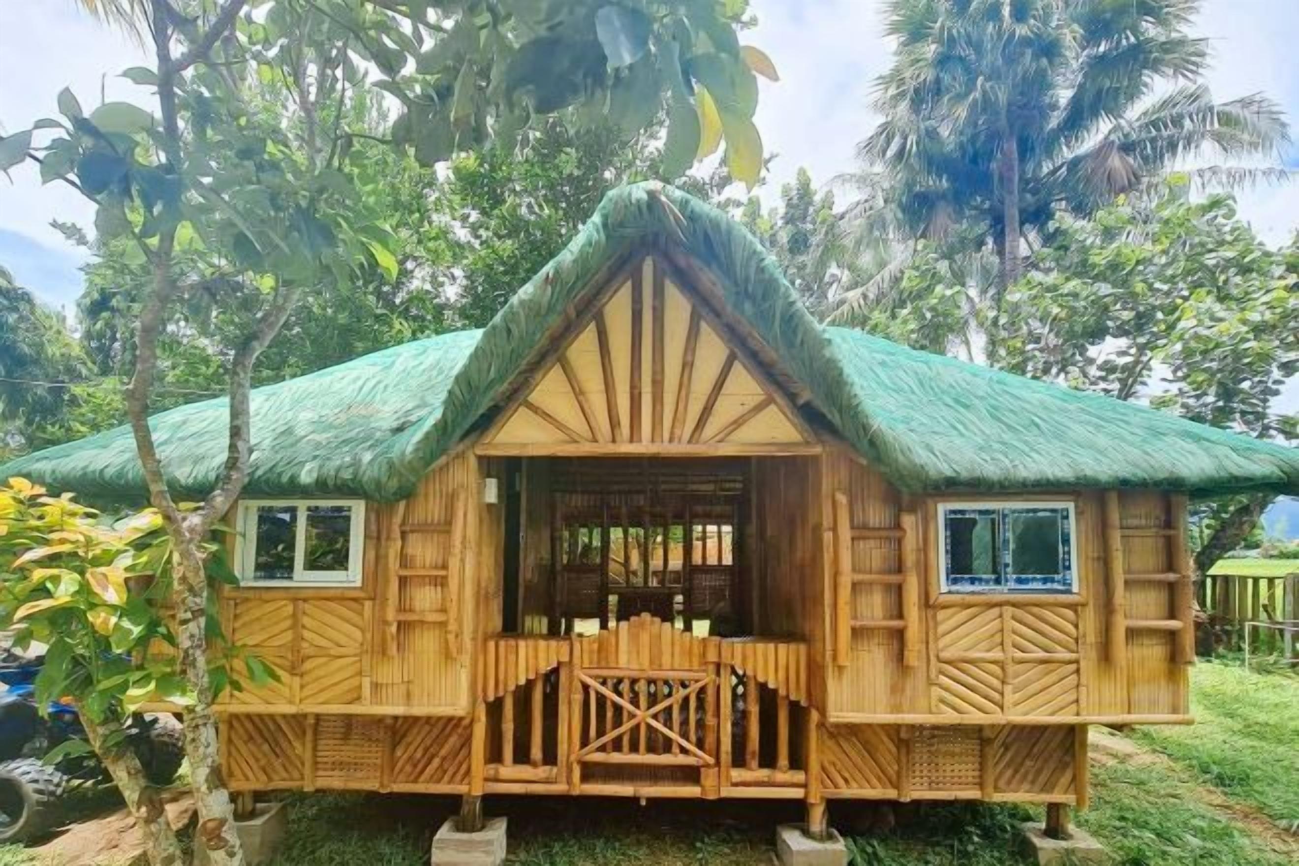 Una casa de madera con techo de paja, una puerta central y ventanas a los lados.