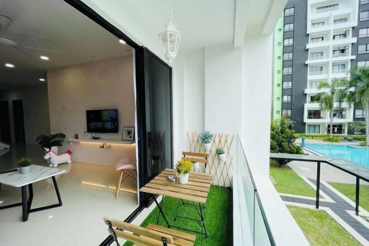 A modern apartment with a balcony, a pool, and a TV in the living area.