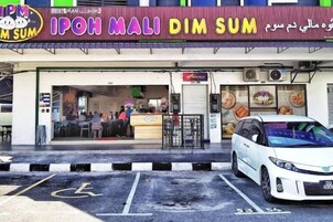 A restaurant with a signboard, a disabled parking space, and a white van parked in front.