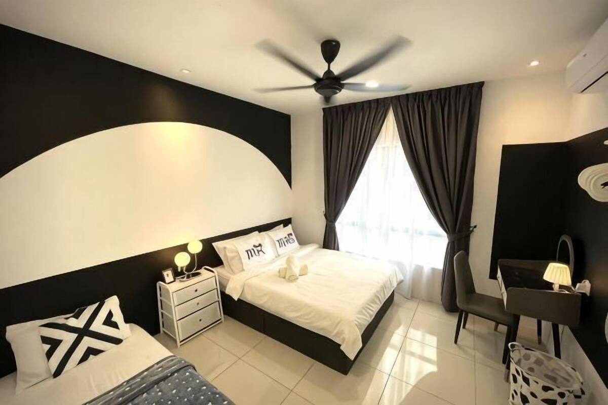 A modern bedroom with a bed, bedside tables, a desk, and a chair.