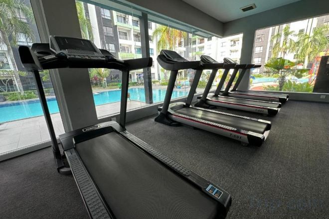A gym with treadmills and a view of a swimming pool.
