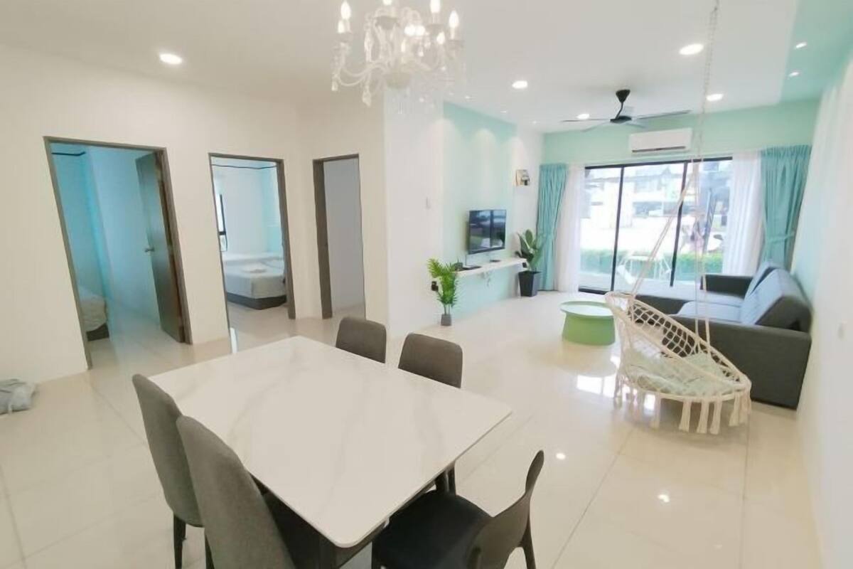 A modern living room with a dining area, a sofa, a TV, and a large window.