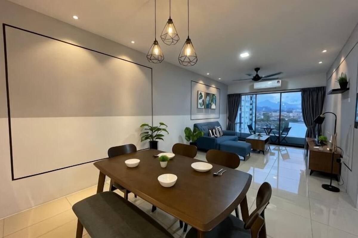 A modern living room with a dining area, large windows, and a view of the city.