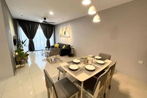 Un salon moderne comprenant un coin repas, un canapé et un ventilateur de plafond.