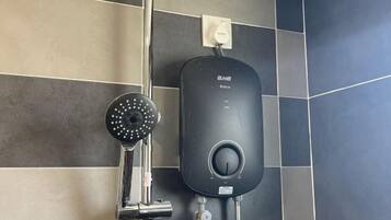 Un baño moderno con ducha empotrada y panel de control.