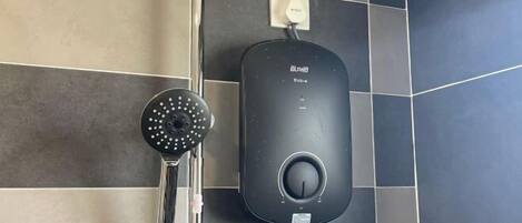 A modern bathroom with a wall-mounted shower and a control panel.