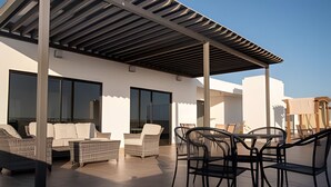 A rooftop terrace with outdoor seating, large windows, and a pergola structure. - Marina cerritos Torre 1 (Mazatlán)