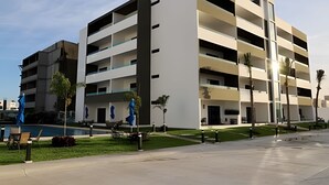 A modern multi-story building with balconies, a pool, and a well-maintained lawn. - Marina cerritos Torre 1 (Mazatlán)