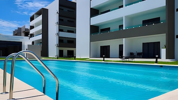 A modern building with a swimming pool, outdoor seating, and a well-maintained lawn. - Marina cerritos Torre 1 (Mazatlán)