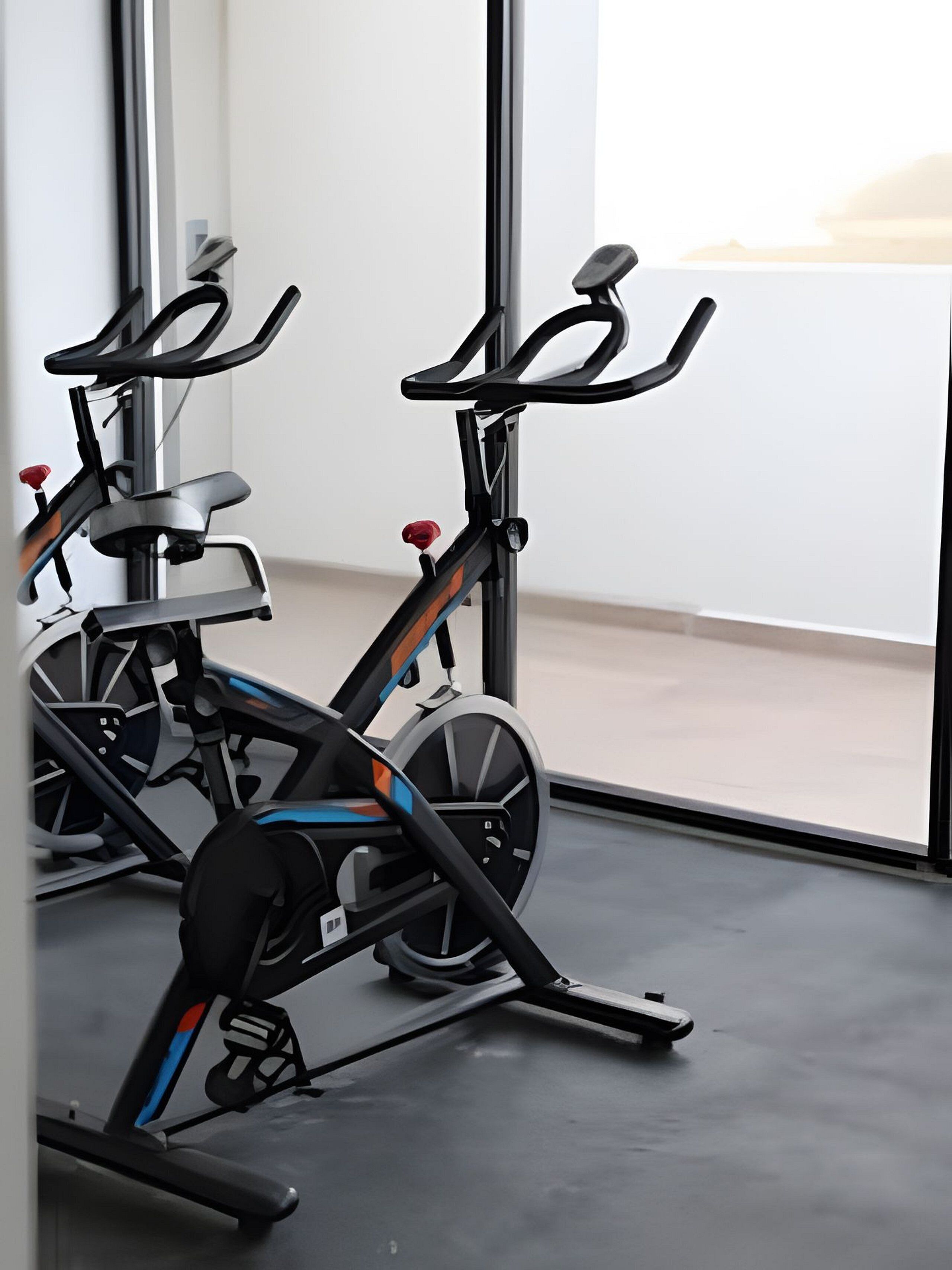 A gym with stationary bikes and a large window.