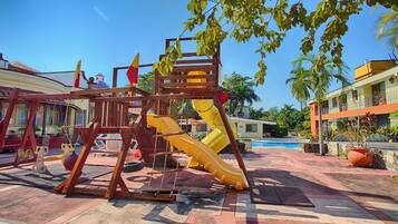 Explore a family-friendly outdoor play area with a multi-level play structure and lush surroundings.