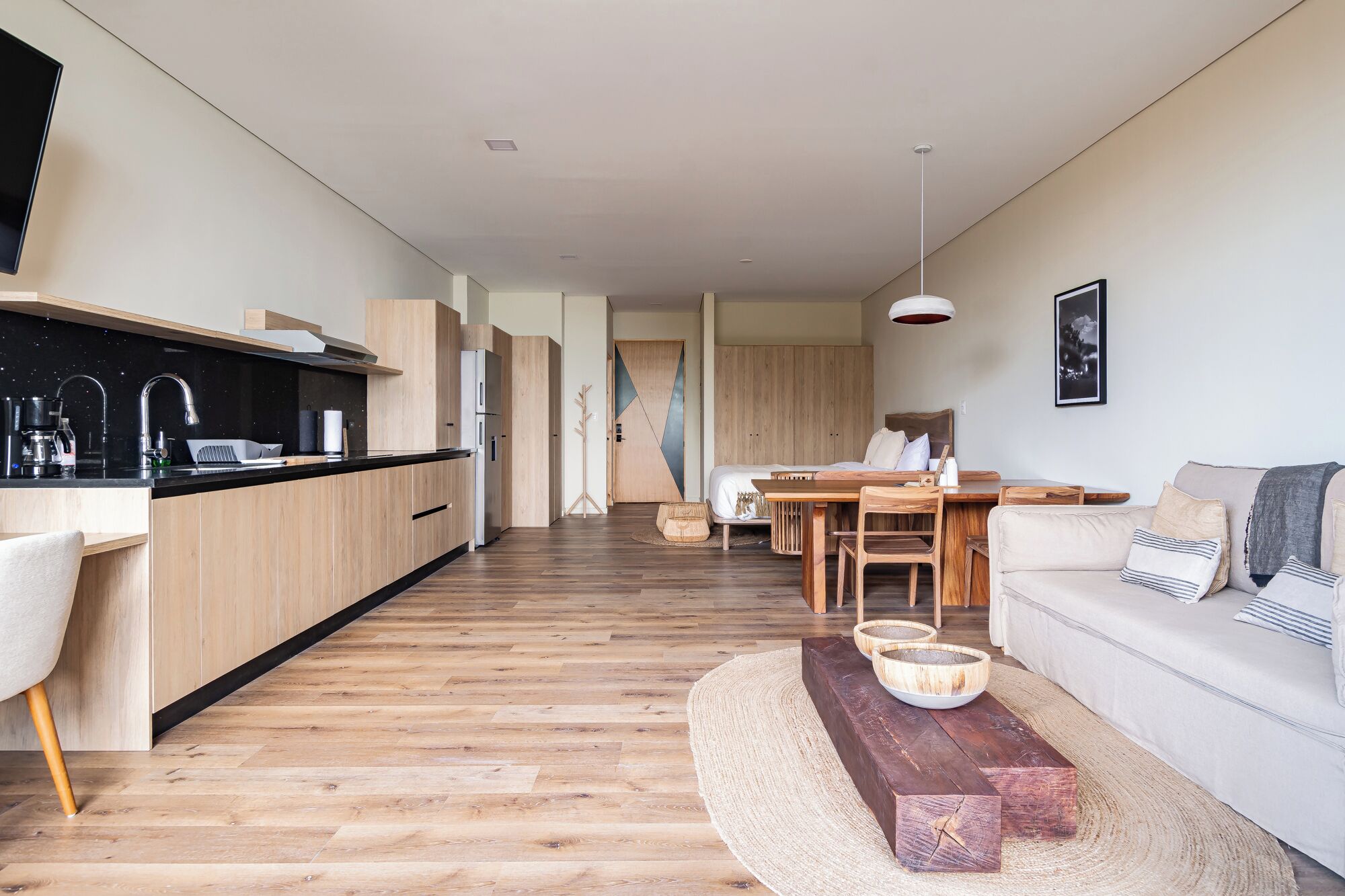 A modern, open-plan living space with a kitchen, dining area, and seating area.
