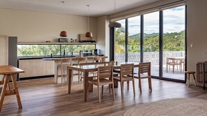 A modern kitchen with wooden cabinetry, a central island, and pendant lighting. - Wave House (Chiltiupan)