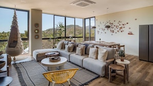 A spacious living room with a large sofa, a hanging chair, and a dining area. - Wave House (Chiltiupan)