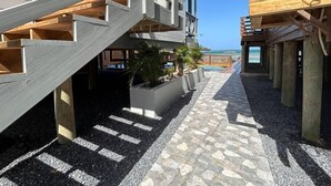 A multi-level wooden building with a central courtyard, outdoor seating area, and a view of the ocean. - Fork Tail Lodge  Secluded 3BR Waterfront Retreat (José Santos Guardiola)