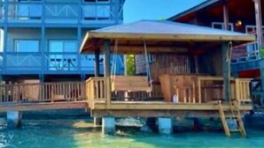 A two-story wooden building with a balcony on the upper floor, situated over water. - Fork Tail Lodge  Secluded 3BR Waterfront Retreat (José Santos Guardiola)