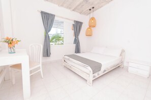 A bedroom with a bed, a desk, a chair, and a window with curtains. - Kpré Coveñas by Bernalo Hotels (Coveñas)