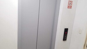 Puerta cerrada de un ascensor con un panel de control en la pared.