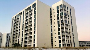 Un edificio de gran altura con varios balcones y techo plano.