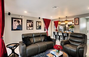 A modern living room with a sofa, armchairs, a coffee table, and a dining area with a kitchen in the background. - Desert Hollywood UofA (Tucson)