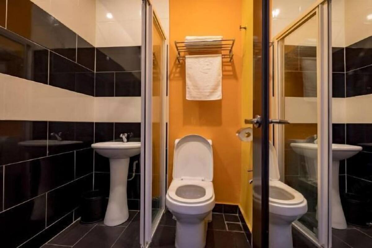 Kylpyhuoneessa on kaksi wc:tä, pesuallas ja pyyheteline.